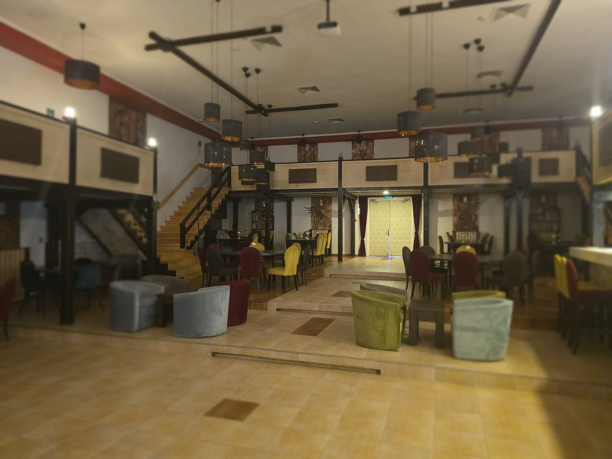 Sala de evenimente de la Pub For You din Târgu Secuiesc, cu mezanin și scară din lemn
