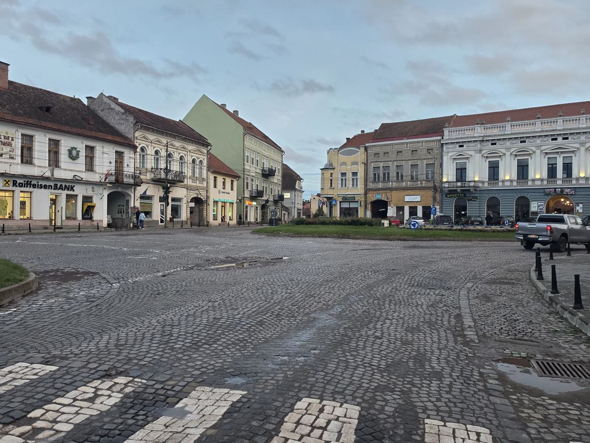 Piața centrală din Târgu Secuiesc, cu fațade istorice și pavaj din piatră cubică